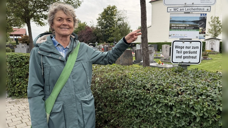 Isolde Schramm-Warmke vor der Tafel, die auf dem Argelsrieder Friedhof für torffreie Erde wirbt.  (Foto: pst)